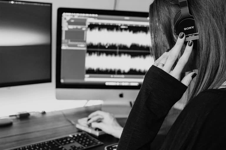 person with a headphone editing waveform sound on a computer - learn about basics of audio editing for video