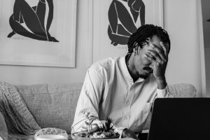 man unhappy in front of laptop because of composition mistakes he made in his photo and video work