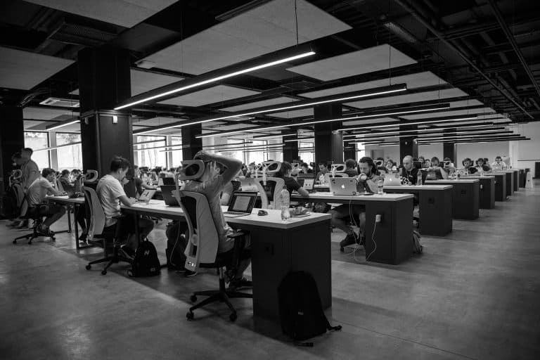 a workplace with many desks and workers - learn about freelancing vs. full-time employment