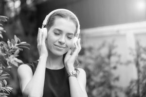 a person with headphones, enjoying her listen - learn how audio editing shape the listener experience