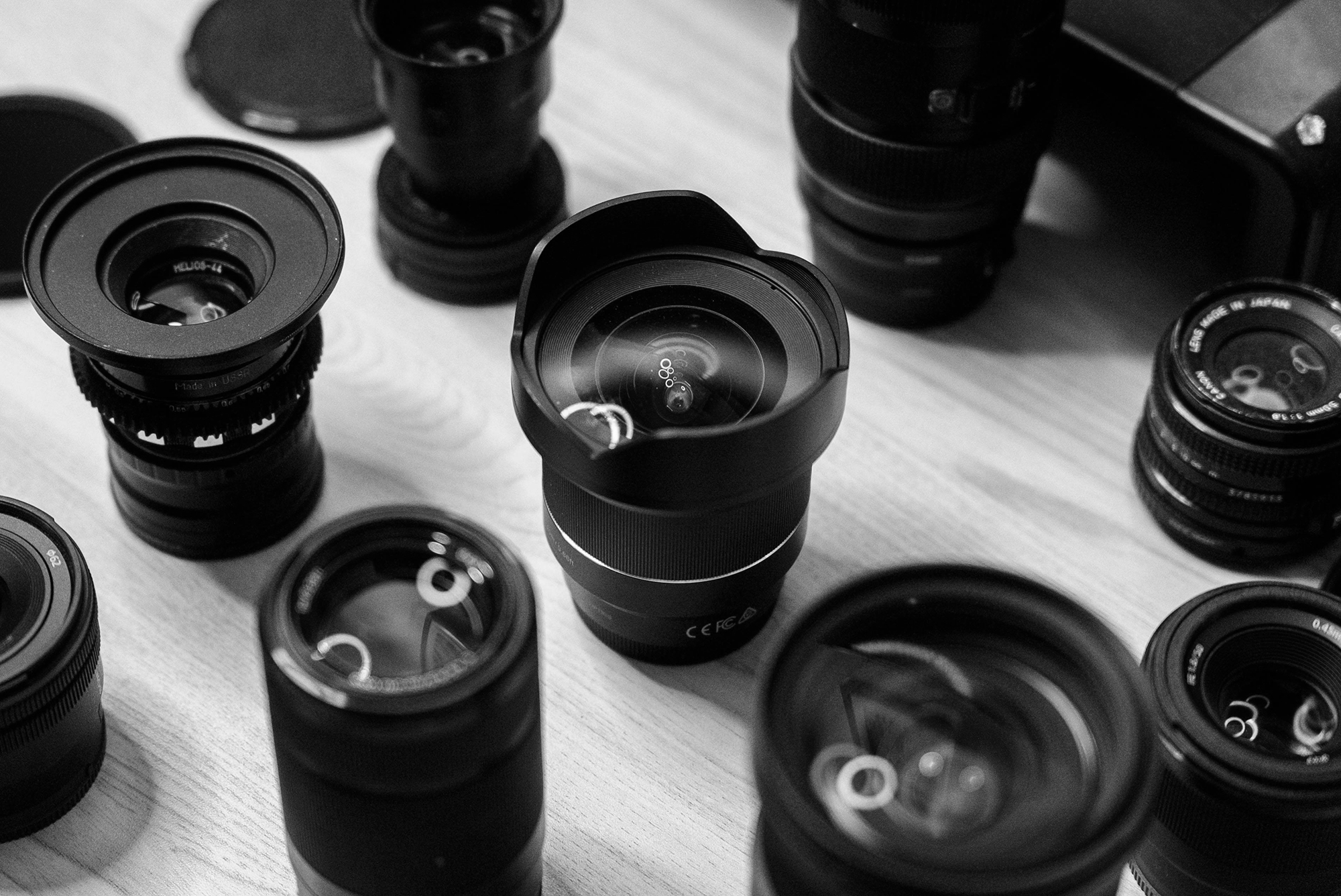 a few camera lenses on a table with different focal lengths - learn about how focal length changes composition and perspective