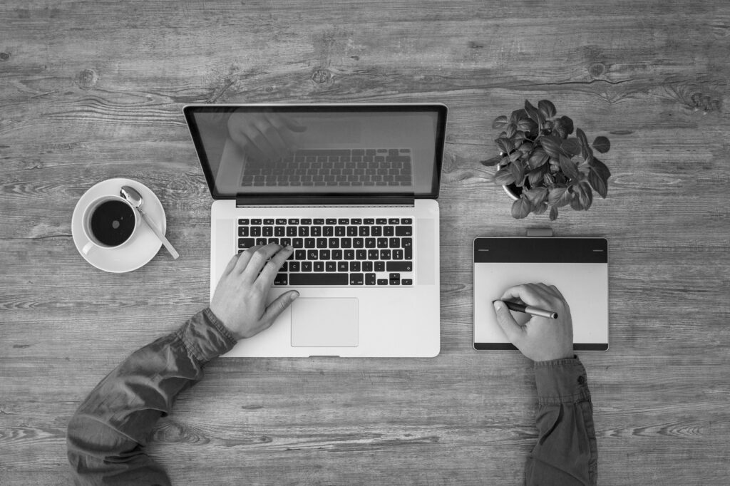 top down shot of a freelance content writer with a notebook and a laptop, writing