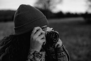 a person, holding a camera to her eyes, makes you wonder how to become a photographer
