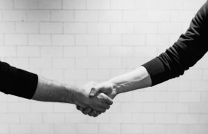 two people shaking hands - How to Find Clients as a Freelancer
