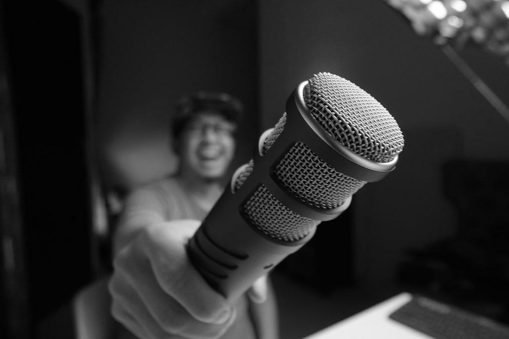 person holding a microphone - learn more about recording audio for video