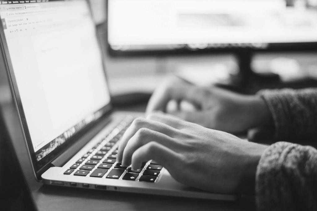 person writing on a laptop - Signs You Need a Freelance Writer