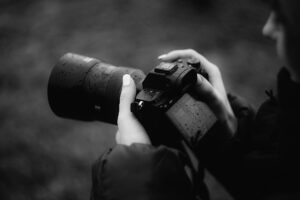 a person holding a camera in the rain - a camera protection guide would be useful to have for these types of situations