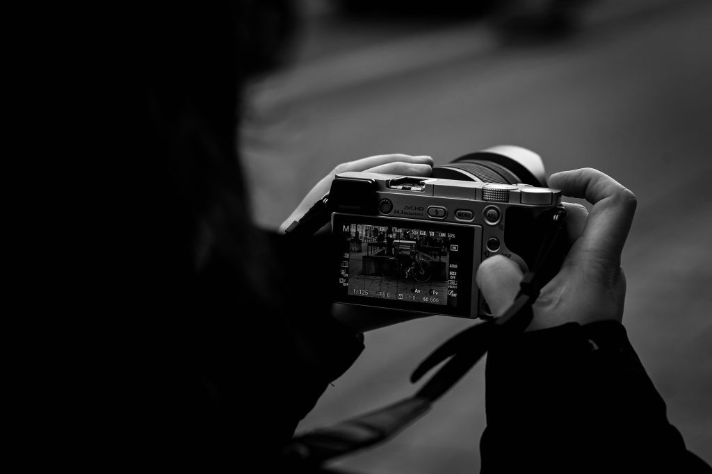 person holding a camera - learn how to hold your camera like a pro