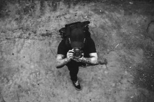 a man with a camera, pointing it up - he is inviting you to ask what is photography? who is a photographer?