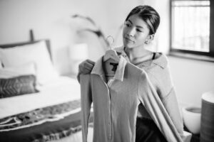 woman holding a shirt in front of herself to see how it looks - learn about what to wear for a portrait photography session