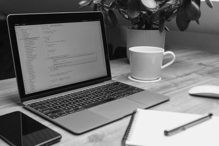Why I Chose Hostinger for My Website (And Why I Stayed) - laptop on a table with cup, notepad and phone