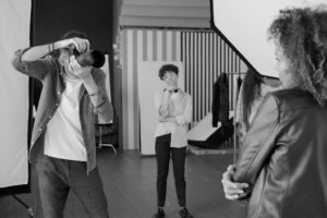 Off-Camera Flash Photography: A Beginner's Guide to Better Portrait Lighting - photographer using an off-camera flash to take portraits in studio